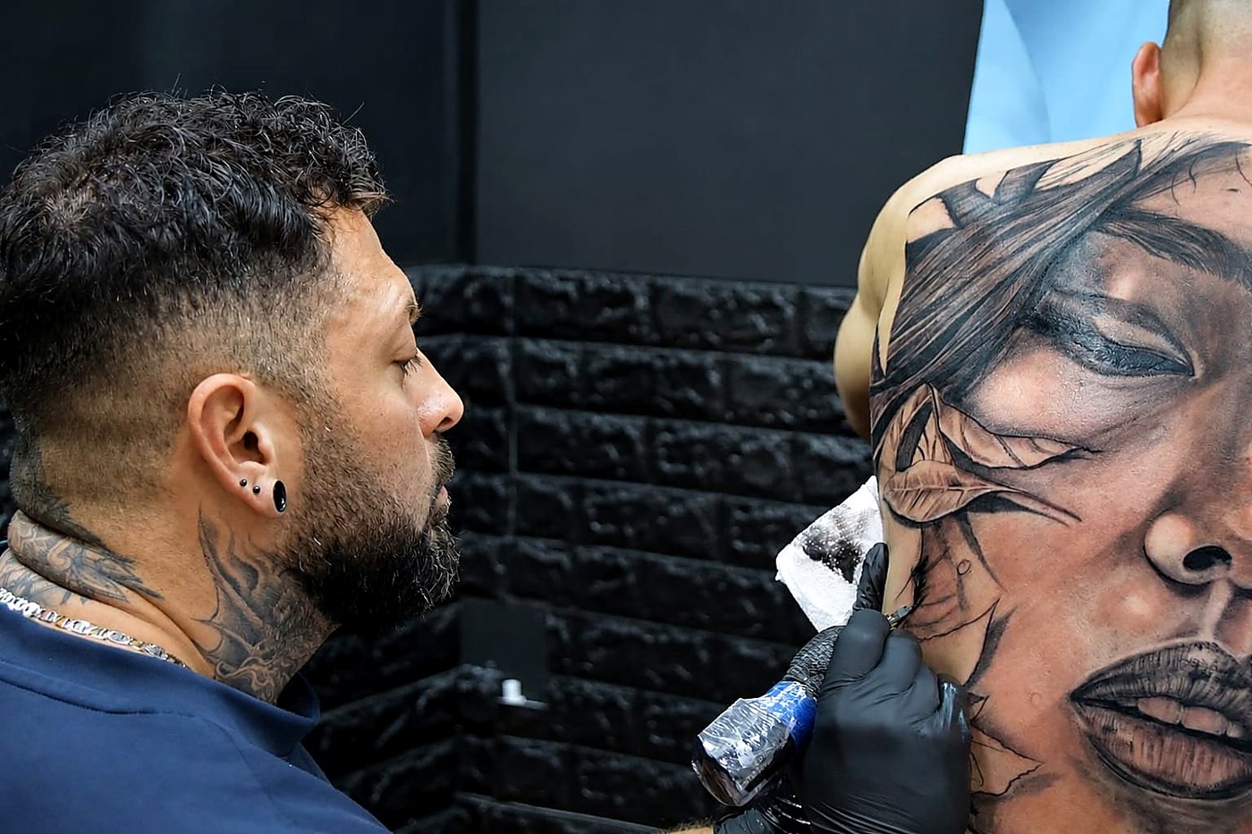 Austin Lopez tatuando un retrato realista en la espalda
