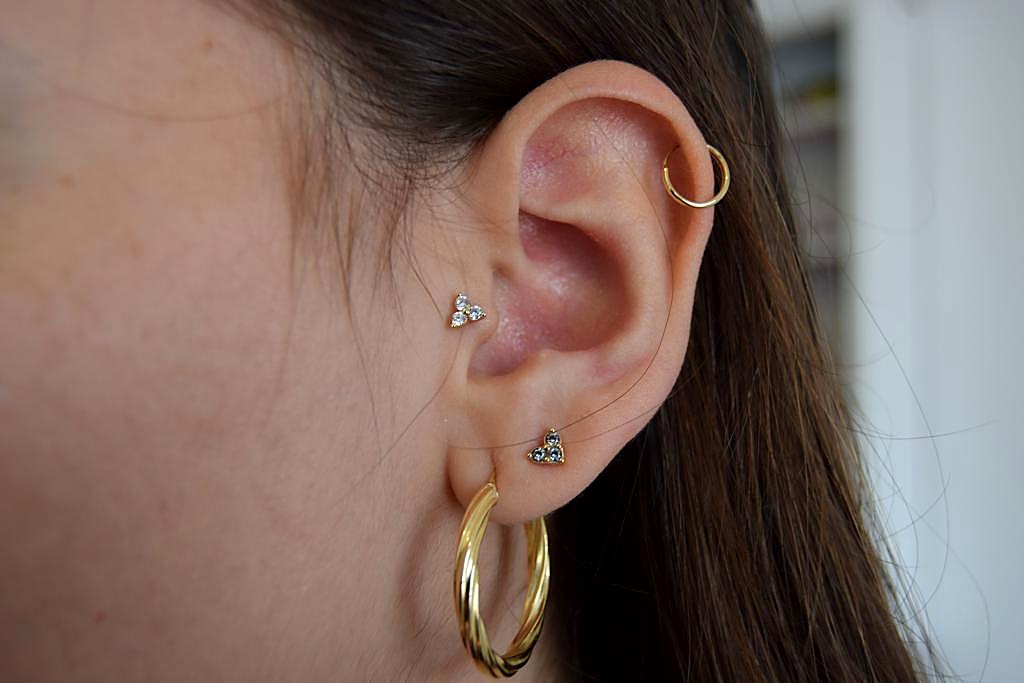 Piercing en oreja con aros dorados